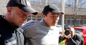 Do Kwon escoltado por oficial de policia