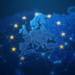 Imagen fotorrealista: emblema del regulador sobre una red de cadena de bloques con una bandera de la UE en una sala de redacción moderna.