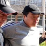 do kwon being escorted by police officer